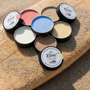 Natural zinc sunscreen tins displayed on surfboard - 100% mineral broad spectrum protection