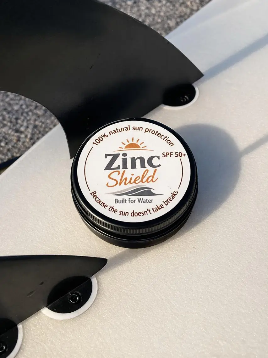 Natural zinc sunscreen by Zinc Shield on surfboard - perfect for surfers and ocean lovers